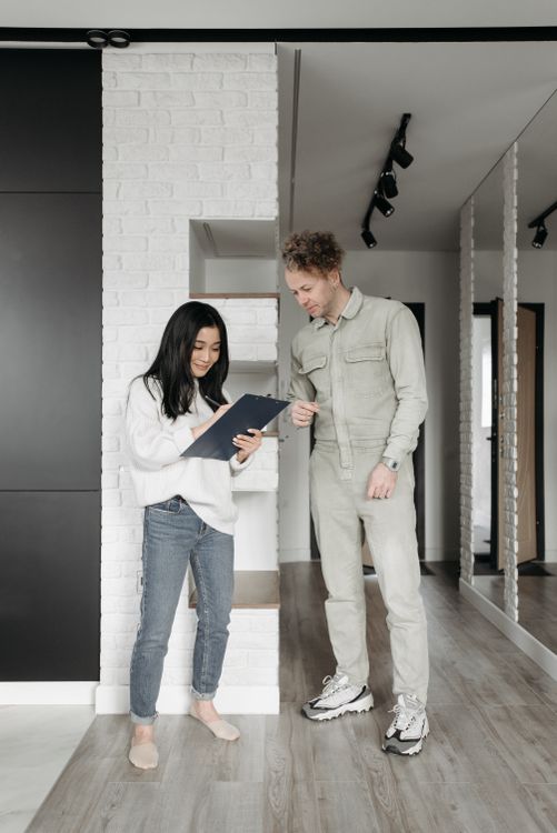 HVAC technician reviewing system options with homeowner — best HVAC field service software helps close replacement jobs faster