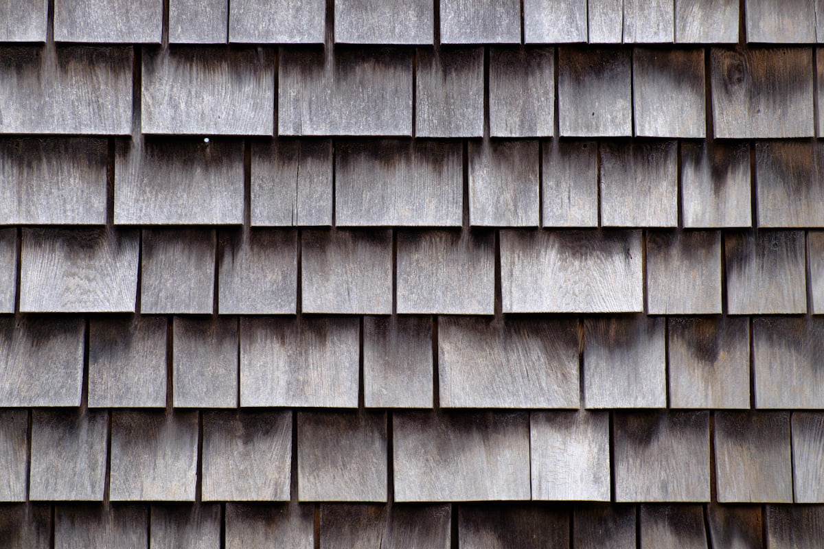 Roofing material samples including asphalt shingles, metal panels, and tile — how much does it cost to replace a roof depends on material choice