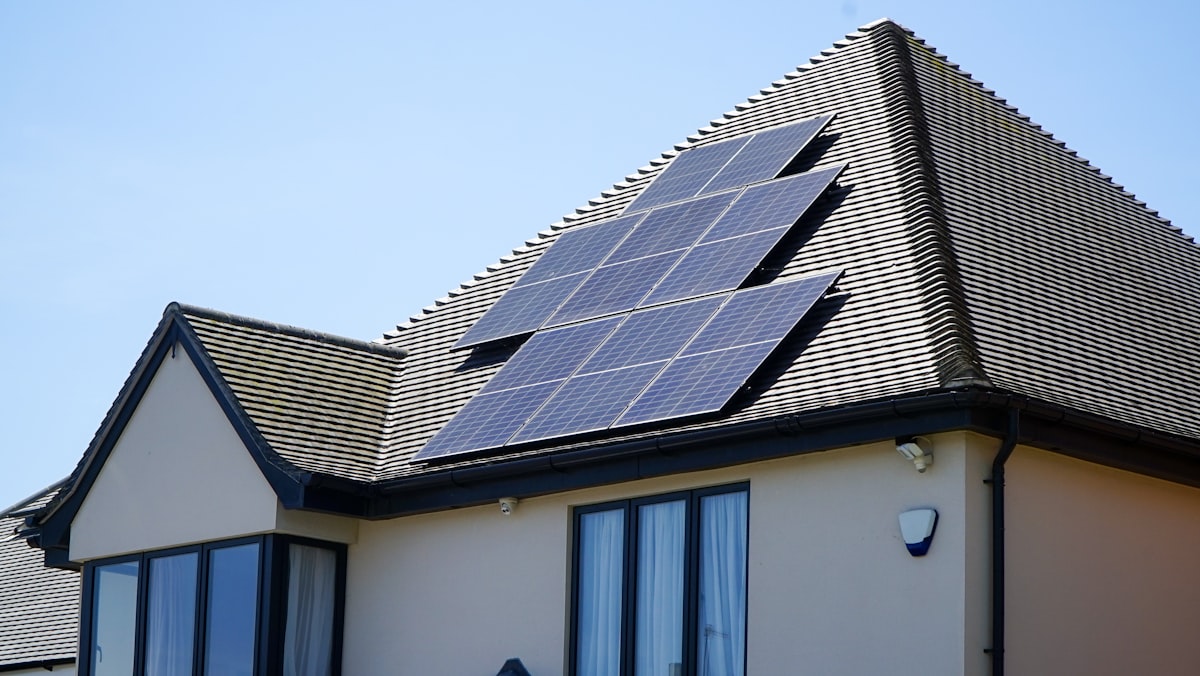 Aerial view of residential solar panel array on rooftop generating clean energy savings