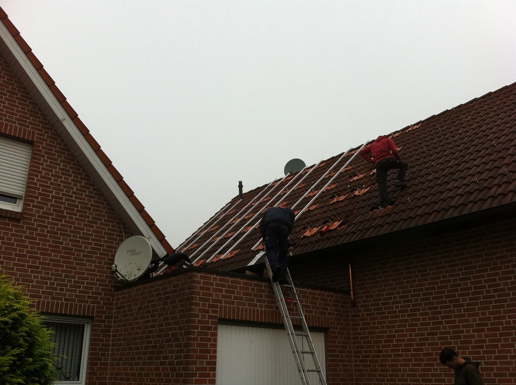 Solar installation crew working on rooftop racking — field scheduling and dispatch managed by solar installer software