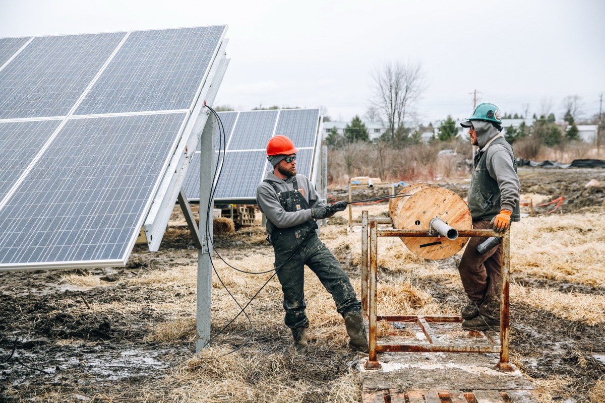Best solar CRM software — solar installer reviewing pipeline and proposals on laptop at job site